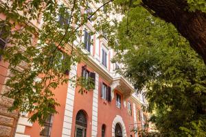 um grande edifício de tijolos com janelas e uma árvore em Trastevere 2.0 em Roma