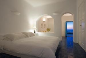 Rúm í herbergi á White Santorini