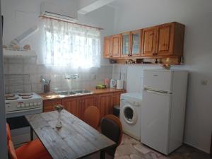 a kitchen with a table and a white refrigerator at Country Side House (View, Parking, wifi, Fenced Yard, Close to the Sea) in Koroni