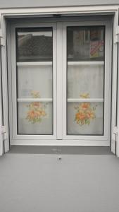 two windows with flowers on them in a building at Casa do Vale Encantado in Furnas