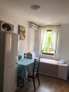 a kitchen with a table and a refrigerator in a room at APARTMANI PETRIJA in Prčanj