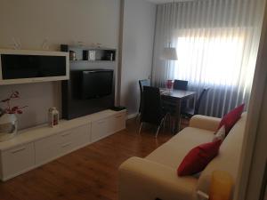 a living room with a couch and a tv and a table at Apartment Fira Barcelona Gran Via in Hospitalet de Llobregat