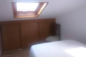 a bedroom with a bed and a skylight at Apartamento Planeta 2º centro in O Porto de Espasante