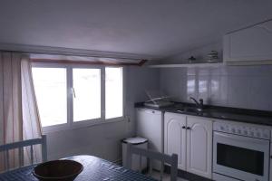 a kitchen with a table and a sink and a window at Apartamento Planeta 2º centro in O Porto de Espasante