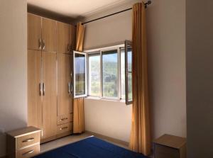 a bedroom with a large window and a blue bed at Rainbow Holiday Apartments in Vlorë +47 photos