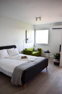 a bedroom with a large bed and a green couch at sky in Pula