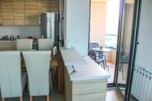 cocina con armarios blancos, mesa y sillas en High End Apartments in Diamond Garden Building, en Skopje