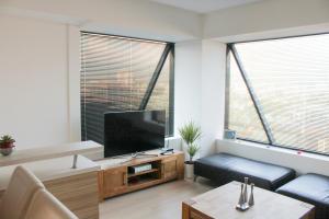 a living room with a flat screen tv and a couch at High End Apartments in Diamond Garden Building in Skopje