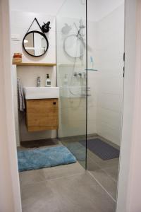 a bathroom with a shower with a sink and a mirror at sky in Pula