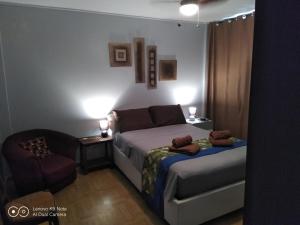 een kleine slaapkamer met een bed en een stoel bij soleil de Pirae in Pirae