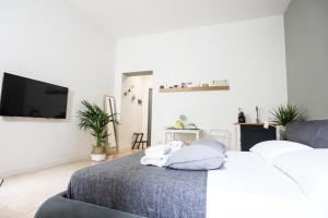 a white bedroom with a bed with a tv on it at Antiche Colonne Suite in Verona