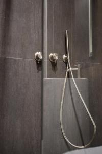 a shower with a hose in a bathroom at Antiche Colonne Suite in Verona
