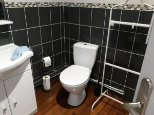 La salle de bains est pourvue de toilettes blanches et de carrelage noir. dans l'établissement Appartements Le Vivier 1er ou rez de chaussée avec parking, à Boulogne-sur-Mer 13 autres photos