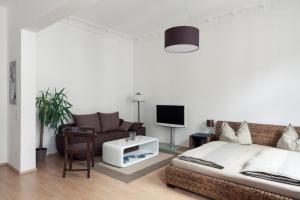 um quarto com uma cama, um sofá e uma televisão em Arbio I Spacious Apart in Center Leipzig em Leipzig