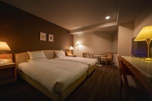 a hotel room with a large bed and a television at Air Terminal Hotel in Chitose