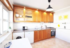 a kitchen with wooden cabinets and a dishwasher at Casa Carapau in Ferrel