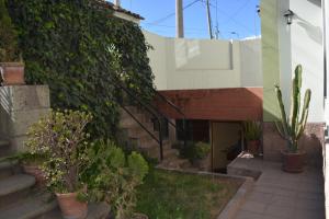 um pátio com vasos de plantas ao lado de um edifício em El Tuco Hotel em Cusco