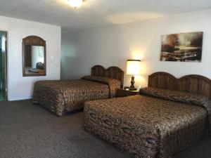 Habitación de hotel con 2 camas y espejo en Rest Assured Inns & Suites, en Montpelier