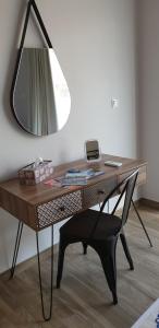 a desk with a mirror and a chair in a room at Ria's Deluxe Apartments in Faliraki