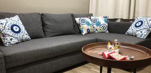 een grijze bank met kussens en een tafel in de woonkamer bij Ria's Deluxe Apartments in Faliraki