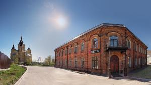 a large red brick building with a clock tower at Nikitin Hotel in Nizhny Novgorod