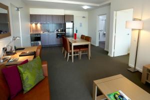 a living room and kitchen with a couch and a table at Quest Palmerston - Darwin in Darwin