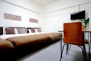 1 dormitorio con 2 camas, escritorio y TV en Mansion Pasture TSUKISAMU Fukuzumi, en Sapporo