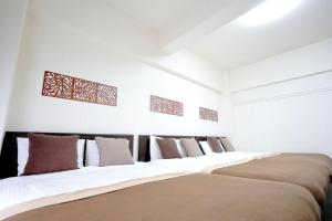 fila de camas en una habitación con paredes blancas en Mansion Pasture TSUKISAMU Fukuzumi, en Sapporo