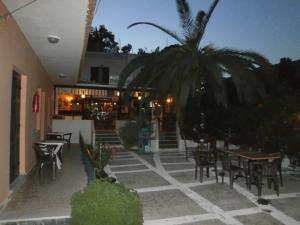 un patio con tavoli e sedie e una palma di Hide Away Ipsos a Ipsos