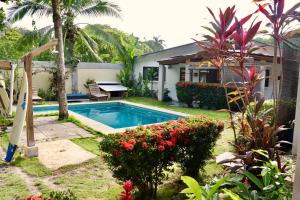 un patio trasero con piscina y una casa en Maoritsio Garden Studios, en Santa Teresa Beach