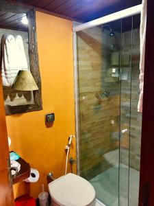 uma casa de banho com uma cabina de duche em vidro e um WC. em Chalé Vista Privilegiada em Campos do Jordão