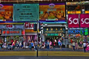 香港にあるNew Day Night Hostel RECEPTION 24 HOUR BLOCK D CHUNGKING MANSION TSIM SHA TSUI KOWLOONNの賑やかな街路を歩く人々