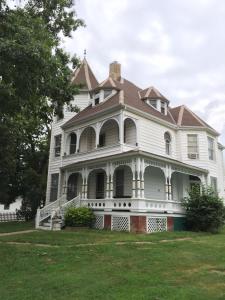 une grande maison blanche avec un toit en gambrel dans l'établissement The Victorian on Main, à Fairfield