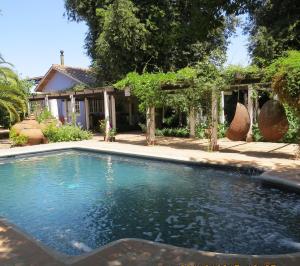 a swimming pool in front of a house at Hotel Boutique Quinta Maria in Santa Cruz