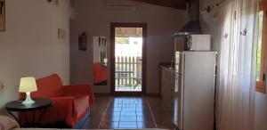 ein Wohnzimmer mit einem roten Sofa und einem Kühlschrank in der Unterkunft Tranquilidad y naturaleza a 800m Playa Migjorn in Playa Migjorn