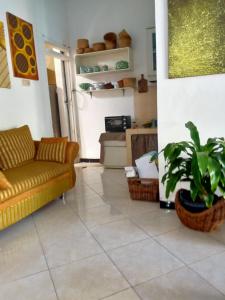 a living room with a couch and a plant at Kalandra Guest House in Ponorogo