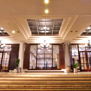 a lobby of a building with a staircase and windows at Royal Hotel Bogor in Bogor