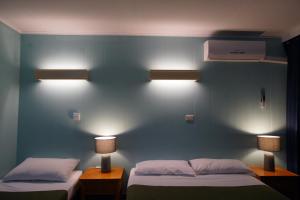 1 dormitorio con 2 camas y 2 luces en la pared en Motel Maroondah en Box Hill