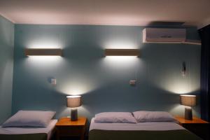 a hotel room with two beds and two lamps at Motel Maroondah in Box Hill
