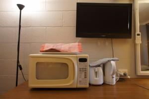 a microwave sitting on top of a wooden table at Motel Maroondah in Box Hill