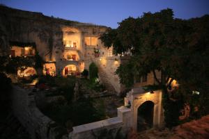 a group of buildings with lights in the night at Elkep Evi Cave Hotel in Ürgüp