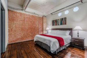 Un dormitorio con una pared de ladrillo y una cama en Regal Stays Corporate Apartments - Downtown Dallas, en Dallas