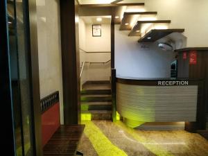 a stairway in a building with a sign that reads reception at Hotel Hanuman in Mangalore