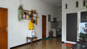 a living room with a white wall and a table at Penginapan Kahan in Batu