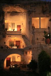 un antiguo edificio de piedra con un puente en la noche en Elkep Evi Cave Hotel, en Ürgüp