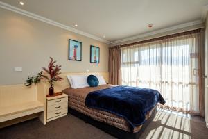 a bedroom with a bed and a large window at Mondello Kaikoura in Kaikoura