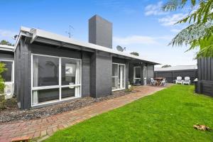 a black house with a lawn in front of it at Mysa Anglesea Sleeps 7 WiFi Netflix Cafes Shops in Anglesea