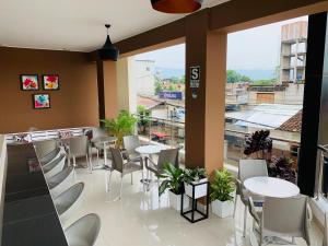 un restaurante con mesas y sillas y una gran ventana en Tropical City en Tarapoto