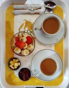 - un plateau avec une tasse de café et une assiette de fruits dans l'établissement Sayami Home, à Pātan