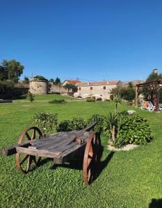 a wooden cart sitting on the grass in a field at Casa da Mina in Carapito